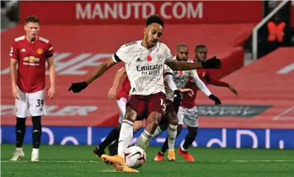  ??  ?? Arsenal’s Pierre-Emerick Aubameyang strokes in the winning penalty to give his side a first Premier League win at Old Trafford since 2006. Photograph: Paul Ellis/PA