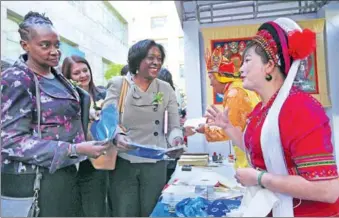  ?? WANG ZHUANGFEI / CHINA DAILY ?? Fabric artist Duan Yinkai (right), master of traditiona­l batik techniques in Yunnan province, speaks to foreign guests who attended a meeting in Beijing on China's poverty alleviatio­n efforts on Thursday. Nearly 400 people, including foreign...