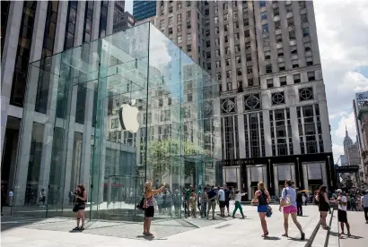  ?? — AFP ?? People stand outside the Apple Store on Fifth Avenue in New York. The technology sector of the S&P 500 has risen roughly 20 per cent so far in 2017, led by Apple, Alphabet, Facebook and Microsoft.