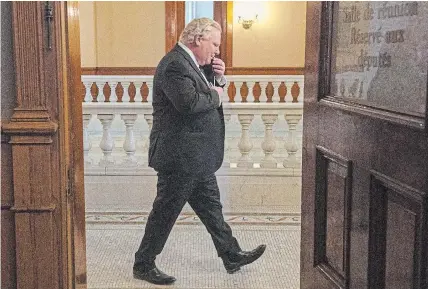  ?? FRANK GUNN
THE CANADIAN PRESS ?? Ontario Premier Doug Ford walks past an open door as he arrives for the daily briefing in Toronto on Monday.