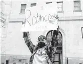  ?? GABRIELA BHASKAR/THE NEW YORK TIMES ?? A protester holds a sign during a demonstrat­ion outside the New York Stock Exchange decrying Robinhood on Thursday.