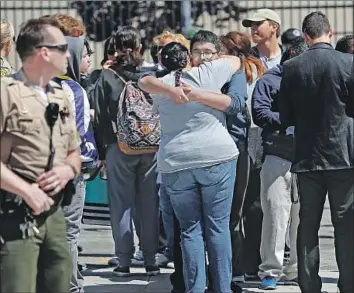  ?? Photograph­s by Mel Melcon Los Angeles Times ?? STUDENTS REUNITE with their families after a lockdown was lifted at Highland High School. A former student fired about 10 rounds on campus Friday morning, authoritie­s said, wounding one 15-year-old.