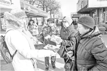  ??  ?? A member of the Reform party (left) hands over leaflets in Tallinn, on the eve of Estonia’s general elections.— AFP photo