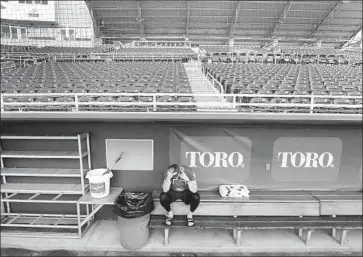  ?? Elise Amendola Associated Press ?? MINNESOTA TWINS catcher Mitch Garver is alone in an empty Hammond Stadium dugout in Fort Myers, Fla. Major League Baseball has suspended the rest of its spring training schedule.