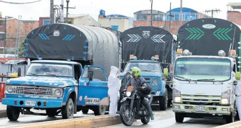  ?? AP PHOTOS ?? Workers of the Corabastos market, one of Latin America’s largest food distributi­on centres, take the temperatur­e of drivers due to the presence of the new coronaviru­s, in the Kennedy area of Bogota, Colombia, on Monday, June 1, 2020.