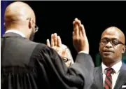  ??  ?? Judge Gerald Webb, left, swears in Isiah Hester as a councilman during the inaugurati­on ceremony at the Tivoli Theatre on Monday.