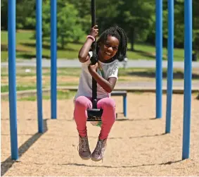  ?? ?? Top: Maya McCray, 8, plays on a zip line swing at Boyle Park in Little Rock.