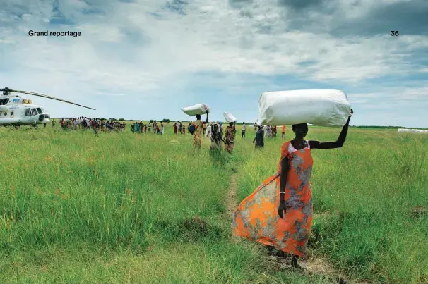  ??  ?? Des centaines de femmes ramassent les sacs de nourriture dans la zone de largage de l’Onu. Elle sera ensuite distribuée dans le village central. Les plus rapides obtiennent un bonus spécial.