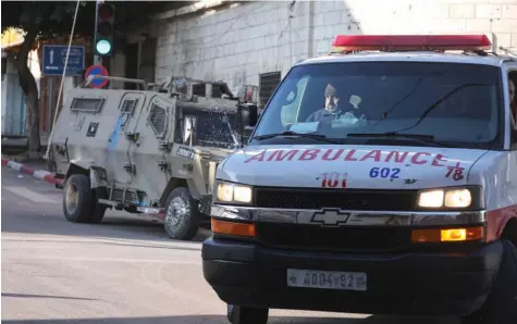  ?? ?? سيارة إسعاف تمر وسط اشتباكات بين فلسطينيين وقوات إسرائيلية خلال دهم في نابلس. ⬛ أ.ف.ب