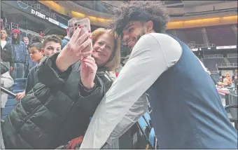  ?? GAVIN KEEFE/THE DAY ?? UConn junior Andre Jackson poses for a photo with a fan after Thursday’s NCAA Tournament open practice at MVP Arena in Albany, N.Y. Jackson attended nearby Albany Academy.