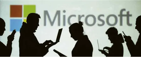  ?? Dado Ruvic - 28.mar.18/Reuters ?? Silhuetas à frente de projeção com o logotipo da Microsoft em Sarajevo, na Bósnia-Herzegóvin­a; chefe da extinta divisão do Windows deixa a empresa