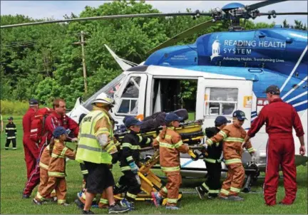  ?? MARIAN DENNIS – DIGITAL FIRST MEDIA ?? Campers at Limerick Youth Firefighti­ng Camp help transport a “patient” from the scene to a medical helicopter. The demonstrat­ion was part of the week-long camp aimed at teaching kids about fire fighting, rescues and safety.