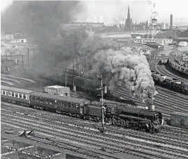  ?? MORTONS RAILWAY MAGAZINE ARCHIVE/ N. E. PREEDY ?? BR Standard 9F 2-10-0 No. 92203 darkens the skies over Birkenhead as it heads for Chester past the locomotive depot with the Stephenson Locomotive Society's Birmingham Birkenhead Railtour on March 5, 1967.