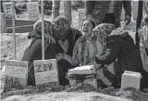  ?? Emrah Gurel/associated Press ?? People mourn at a cemetery Friday as they bury their loved ones, victims of the Monday earthquake in Adiyaman, Turkey.