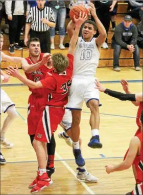  ?? BARRY BOOHER — THE NEWS-HERALD ?? Madison’s Dhel Duncan-Busby drives into a host of Chardon defenders. Duncan-Busby scored 28 points in Madison’s 69-55 win.