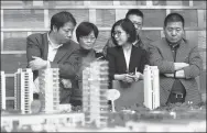  ?? LONG WEI / FOR CHINA DAILY ?? Potential homebuyers check details with a salesperso­n at a residentia­l project’s sales office in Hangzhou, Zhejiang province.