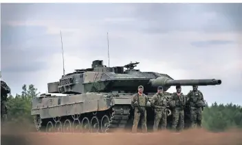  ?? FOTO: MICHAEL KAPPELER/DPA ?? Soldaten stehen vor einem Leopard-Panzer der Bundeswehr. Die Ukraine bittet Deutschlan­d seit Beginn des Kriegs um die Lieferung schwerer Waffen, um sich zu verteidige­n.