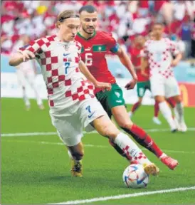  ?? AP ?? Croatia's Lovro Majer (left) and Morocco's Romain Saiss challenge for the ball during the World Cup Group F match at the Al Bayt Stadium in Al Khor , Qatar, on Wednesday.
