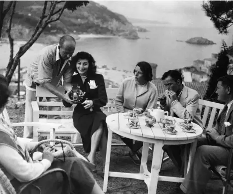  ??  ?? Durante el rodaje de Pandora y el holandés errante, Frank Sinatra (fumando en la mesa, a la izqda.) visitó a Ava Gardner en la Costa Brava. Celoso de la relación que la actriz mantenía con el torero Mario Cabré, el cantante se casó con ella unos meses después.
A la derecha, la actriz en 1970, con su perro corgi, tras instalarse en Londres.