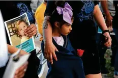  ??  ?? Althea Lopez, 6, whose cousin is James, attends the vigil. The boy’s mother has been arrested on child abandonmen­t/endangerme­nt charges and is not telling police where her son might be.