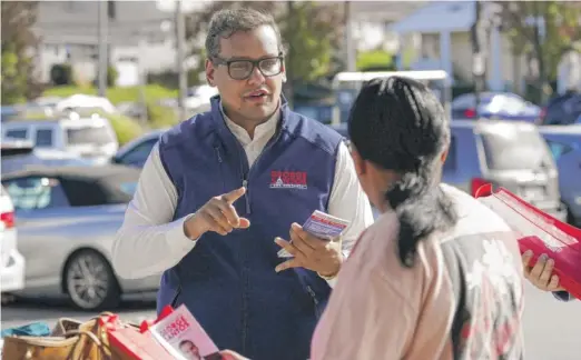  ?? MARY ALTAFFER/AP ?? U.S. Rep.-elect George Santos talks to a voter while campaignin­g on Nov. 5 in Glen Cove, N.Y.