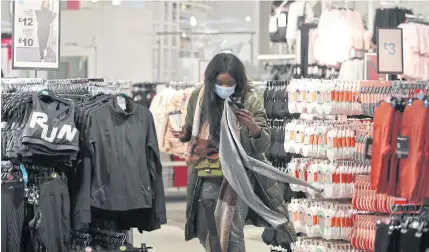  ?? REUTERS ?? A woman shops at a store in Birmingham after the UK reopened its doors, finally ending a third lockdown imposed in early January due to the ongoing coronaviru­s, yesterday.