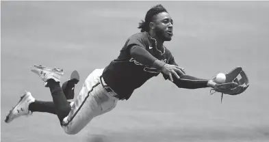  ??  ?? Braves second baseman Ozzie Albies tries to make a diving catch during a simulation game. JOHN DAVID MERCER/ USA TODAY SPORTS