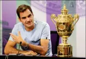  ?? ASSOCIATED PRESS ?? ROGER FEDERER SPEAKS NEXT TO the Men’s Single’s tennis trophy he won on Sunday during a photo call at The All England Lawn Tennis and Croquet Club in Wimbledon, England, Monday. Federer’s eighth Wimbledon title pushed him back up to No. 3 in the ATP...