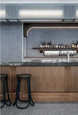  ??  ?? Above — The long, double-sided bar attached to the kitchen serves all areas, increasing efficiency.