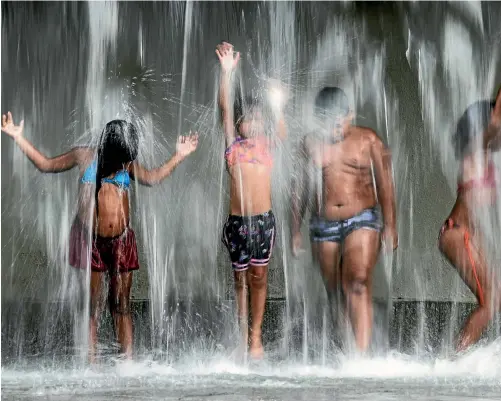  ??  ?? How to beat the heat? These kids found one solution.