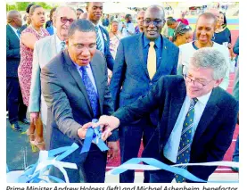  ?? FILE ?? Prime Minister Andrew Holness (left) and Michael Ashenheim, benefactor, cut the ribbon for the official opening of the Ashenheim Stadium at Jamaica College on February 20. Looking on are R. Danny Williams (behind Holness), then Education Minister Ruel Reid (centre), and Energy Minister Fayval Williams.