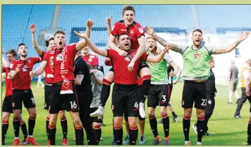  ??  ?? WE’VE DONE IT: Morecambe players celebrate staying up after their draw at Coventry