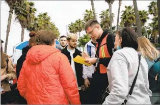  ?? ADRIANA HELDIZ U-T ?? A volunteer in Tijuana reads out loud Thursday the names of Ukrainian families that are next in line to meet with U.S. Customs and Border Protection officials to request asylum.