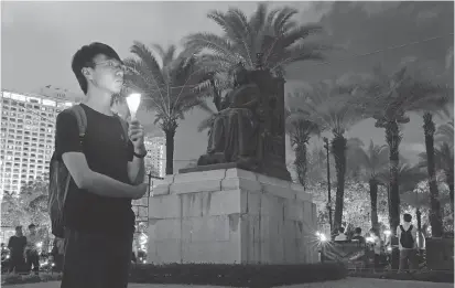  ?? KIN CHEUNG/THE ASSOCIATED PRESS ?? A man attends a candleligh­t vigil at Victoria Park in Hong Kong on Monday to mark the anniversar­y of the Tiananmen massacre, which claimed the lives of hundreds — if not thousands — of pro-democracy protesters on June 4, 1989.