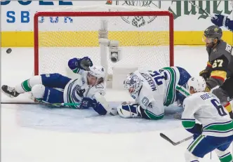  ?? The Canadian Press ?? Sure, Jacob Markstrom is making a lot of saves, but so is everyone else on the Vancnouver Canucks, including defenceman Troy Stecher, who helps out his goalie here.