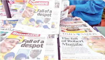  ??  ?? A newspaper vendor arranges local dailies with headlines about the situation in Zimbabwe in Nairobi. — AFP photo