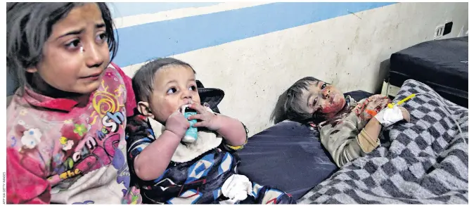  ??  ?? Wounded children receive treatment at a makeshift hospital in Idlib