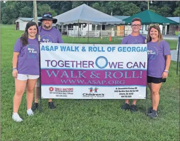  ??  ?? Above: The Ingle family stands by the sign for the first annual ASAP Walk and Roll of Georgia.