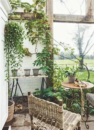  ??  ?? ENTRANCE
Annabelle designed this rustic A-frame structure to provide covered access from the garden to the utility room. The swing to the side is a whimsical touch.
GLASS HOUSE A complement­ary addition to the 18th-century cottage, this was built to enjoy the panoramic views and for potting plants. Furniture and pots, all Potting Shed