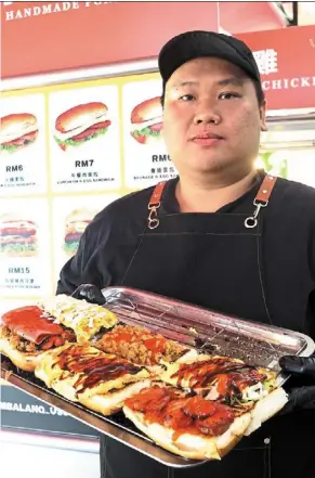  ?? Photos: Chan TAK KONG/THE ?? Ng showing the burgers at his stall. star
