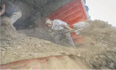  ?? BRIAN INGANGA/AP ?? Farmers offload livestock manure from a truck in Kiambu, Kenya, that will be used to fertilize crops due to the soaring cost of fertilizer they say they now can’t afford to buy.