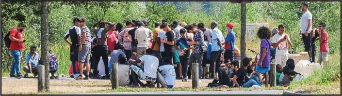  ??  ?? WAITING IN HOPE: Migrants at the new Jungle in Calais yesterday