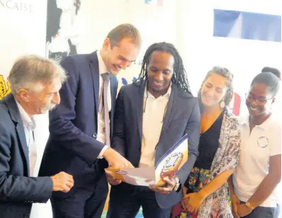  ?? PHOTO BY MICHAEL RECKORD ?? Examining the project’s brochure are (from left) Pierre Lemaire, Laurent Gueslin, Alando Terrelonge, Sebrina Lipoff and Wendy Dyemma.