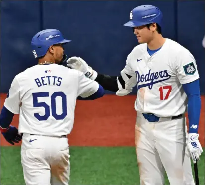  ?? JUNG YEON-JE AFP VIA GETTY IMAGES ?? The Dodgers' Mookie Betts celebrates with Shohei Ohtani after hitting a two-run homer against the Padres last Thursday in Seoul.