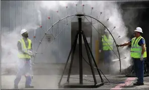  ?? AP ?? Workers test a spray to be used for controllin­g contaminat­ed dust in the decommissi­oning process at Vermont Yankee Nuclear Power Station in Vernon, Vt., one of several shuttered nuclear power plants in the U.S. that are being bought by cleanup companies that promise to speed up the decontamin­ation process.