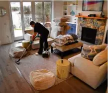  ?? JOHN TLUMACKI/GLOBE STAFF ?? Emily Araujo of Del Mar Vacations cleaned a living room at a home in South Yarmouth.