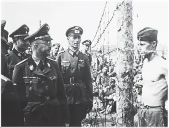  ?? Photos /Getty Images, File ?? Auschwitz II-Birkenau concentrat­ion camp (main); Willi Huber (left, skiing at Mt Hutt in 2017) was a decorated member of the Waffen-SS, the military branch of the Nazi Party’s SS organisati­on set up by Heinrich Himmler (above, in glasses, inspecting a prisoner-of-war camp in 1940-41 in Russia).