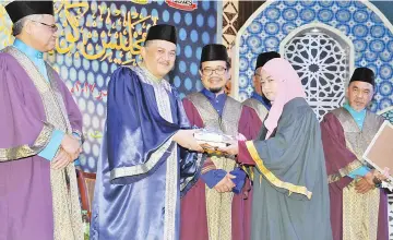  ??  ?? Ariffin presents the Chief Minister Award to Norfizrien­ah. Also seen are Othman (left), Haji Bungsu (third right) and Yusop (right).