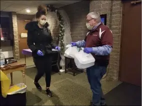  ?? JORDANA JOY — THE MORNING JOURNAL ?? Zanayah Dampier, left, takes a few meals from German’s Villa owner Cliff German for delivery at the banquet hall, 3330Libert­y Ave. in Vermilion.