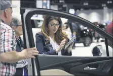  ?? DAVID ZALUBOWSKI - THE ASSOCIATED PRESS FILE PHOTO ?? A salesperso­n uses a tablet to find a car for prospectiv­e buyers as they look over a vehicle at the auto show last year in Denver. Historical­ly, Labor Day weekend is an opportune time to get a great deal on a new vehicle. But this Labor Day weekend, the great deal could very well come about by selling or trading in your car.